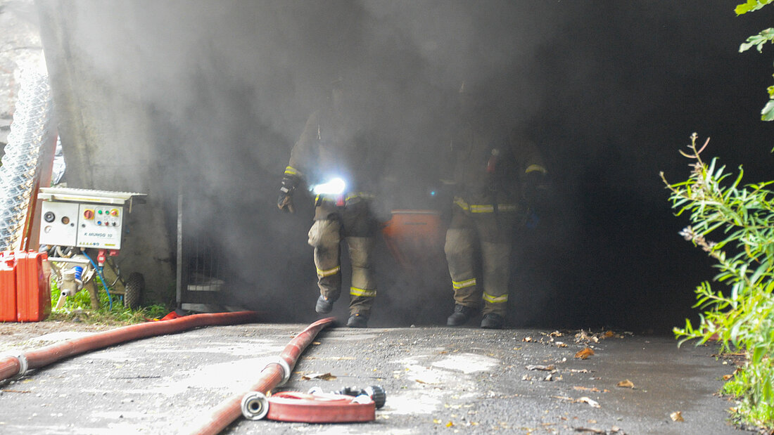 Piottino real fire trial Two firefighters emerge from a tunnel with heavy smoke during a fire trial in the Piottino Tunnel