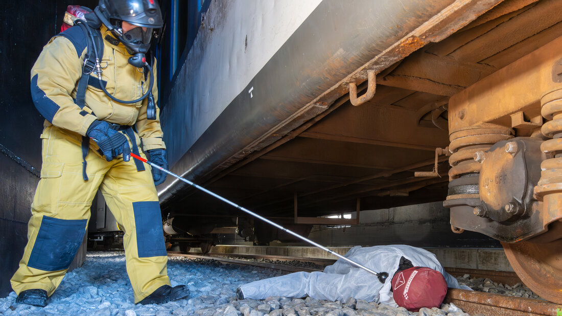 Firefighter practises searching for people on the railway track with a search stick