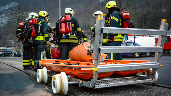 Feuerwehrangehörige transportieren Material mit einer Rollpalette