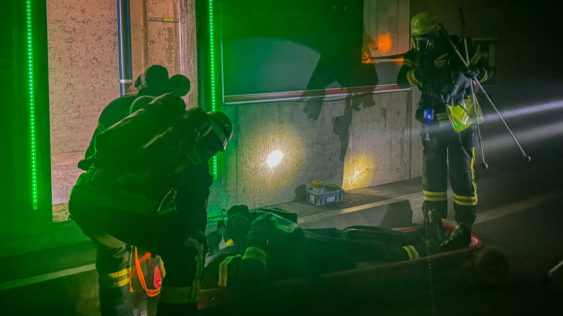 Feuerwehrangehörige üben das Retten einer Person aus einem Tunnel