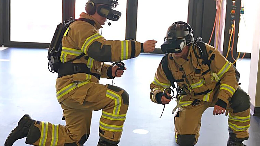 Zwei Feuerwehrangehörige mit VR-Ausrüstung trainieren gemeinsam